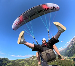 Passager souriant lors de son vol en parapente biplace offert en bon cadeau