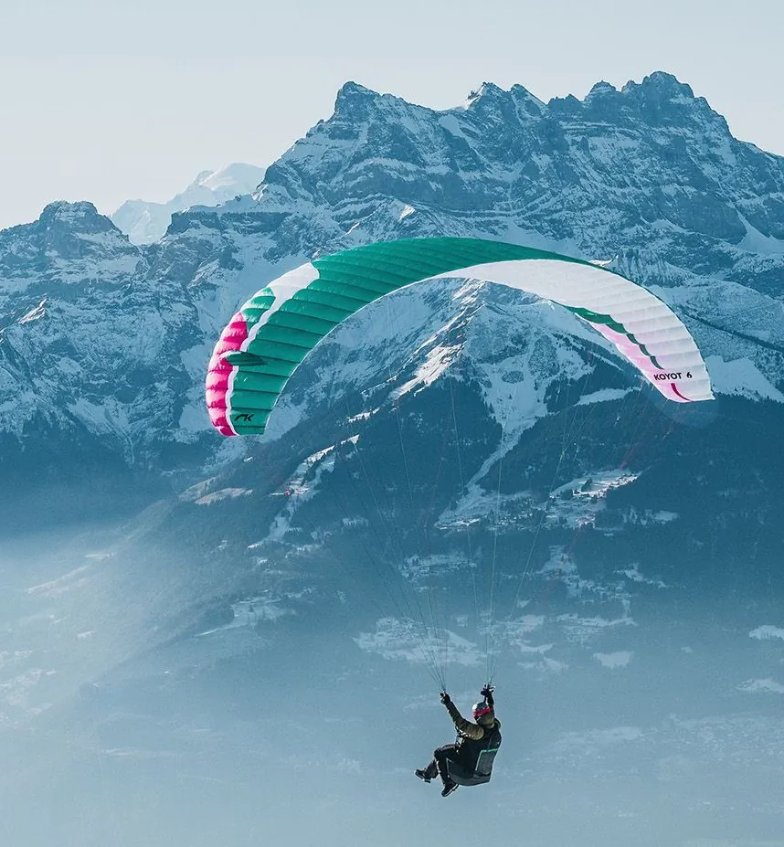 Koyot 6 couleur Guava en vol avec les alpes enneigée en fond