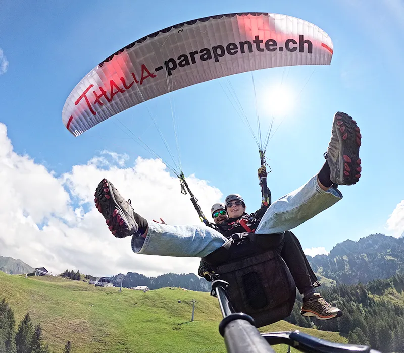 Passager souriant lors d'un vol en parapente biplace à Charmey (Gruyère) avec Thalia Parapente