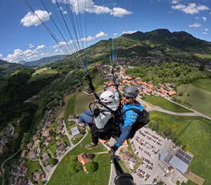 Vue sur le village de Charmey pendant un vol en parapente biplace