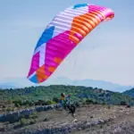 Pilote en vol montagne sous une BGD KISS 2 couleur Flamingo