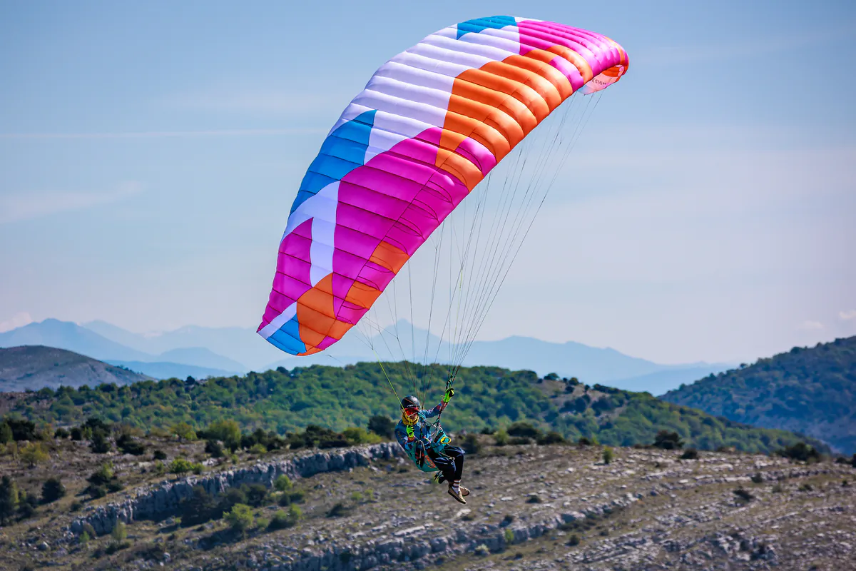Pilote en vol montagne sous une BGD KISS 2 couleur Flamingo